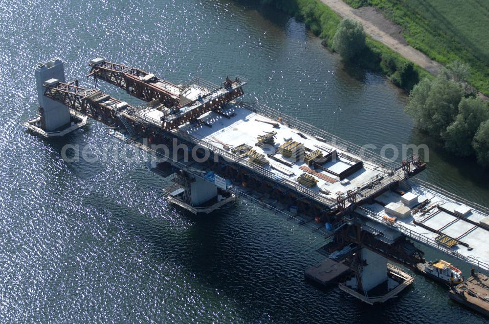 Rattmannsdorf from above - Blick auf die Vorschub- Bauarbeiten an der Saale-Elster-Talbrücke über den Rattmannsdorfer See. Das Beton- Viadukt mit insgesamt 8, 5 Kilometern Länge wird teilweise mit großen Baugerüsten in so genannter Vor-Kopf-Bauweise errichtet, bei der zur Schonung der Umwelt alle Arbeitsschritte von der fertigten Brücke aus erfolgen und keine Baustraßen notwendig sind. Die ICE - Neubaustrecke im Projekt VDE 8 Nürnberg-Berlin der Deutschen Bahn soll 2015 in Betrieb gehen und wird das bisher längste Brückenbauwerk Deutschlands sein. Bauausführende Firmen sind die Hochtief Construction AG, Adam Hörnig, Gerdum und Breuer; Franki Grundbau; Doka Schalungstechniker; BBV Vorspanntechnik; Röro Traggerüstsysteme; Oevermann Hoch- und Tiefbau, Teupe & Söhne Gerüstbau GmbH, Alpine Bau und Arcelormittal. View of the construction of the Saale-Elster Viaduct on the Rattmannsdorfer lake.