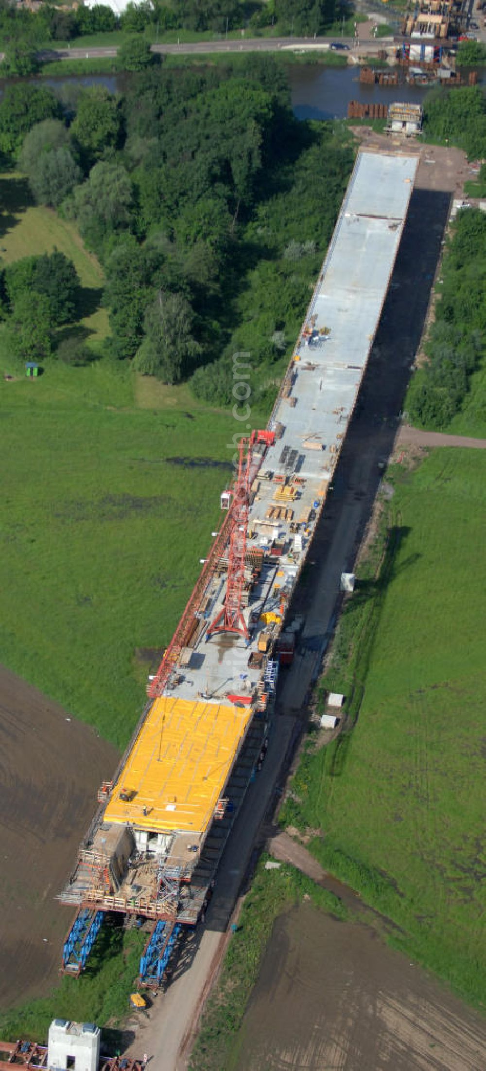 Rattmannsdorf from the bird's eye view: Blick auf die Vorschub- Bauarbeiten an der Saale-Elster-Talbrücke über den Rattmannsdorfer See. Das Beton- Viadukt mit insgesamt 8, 5 Kilometern Länge wird teilweise mit großen Baugerüsten in so genannter Vor-Kopf-Bauweise errichtet, bei der zur Schonung der Umwelt alle Arbeitsschritte von der fertigten Brücke aus erfolgen und keine Baustraßen notwendig sind. Die ICE - Neubaustrecke im Projekt VDE 8 Nürnberg-Berlin der Deutschen Bahn soll 2015 in Betrieb gehen und wird das bisher längste Brückenbauwerk Deutschlands sein. Bauausführende Firmen sind die Hochtief Construction AG, Adam Hörnig, Gerdum und Breuer; Franki Grundbau; Doka Schalungstechniker; BBV Vorspanntechnik; Röro Traggerüstsysteme; Oevermann Hoch- und Tiefbau, Teupe & Söhne Gerüstbau GmbH, Alpine Bau und Arcelormittal. View of the construction of the Saale-Elster Viaduct on the Rattmannsdorfer lake.