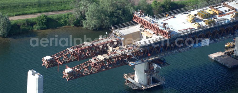 Aerial image Rattmannsdorf - Blick auf die Vorschub- Bauarbeiten an der Saale-Elster-Talbrücke über den Rattmannsdorfer See. Das Beton- Viadukt mit insgesamt 8, 5 Kilometern Länge wird teilweise mit großen Baugerüsten in so genannter Vor-Kopf-Bauweise errichtet, bei der zur Schonung der Umwelt alle Arbeitsschritte von der fertigten Brücke aus erfolgen und keine Baustraßen notwendig sind. Die ICE - Neubaustrecke im Projekt VDE 8 Nürnberg-Berlin der Deutschen Bahn soll 2015 in Betrieb gehen und wird das bisher längste Brückenbauwerk Deutschlands sein. Bauausführende Firmen sind die Hochtief Construction AG, Adam Hörnig, Gerdum und Breuer; Franki Grundbau; Doka Schalungstechniker; BBV Vorspanntechnik; Röro Traggerüstsysteme; Oevermann Hoch- und Tiefbau, Teupe & Söhne Gerüstbau GmbH, Alpine Bau und Arcelormittal. View of the construction of the Saale-Elster Viaduct on the Rattmannsdorfer lake.