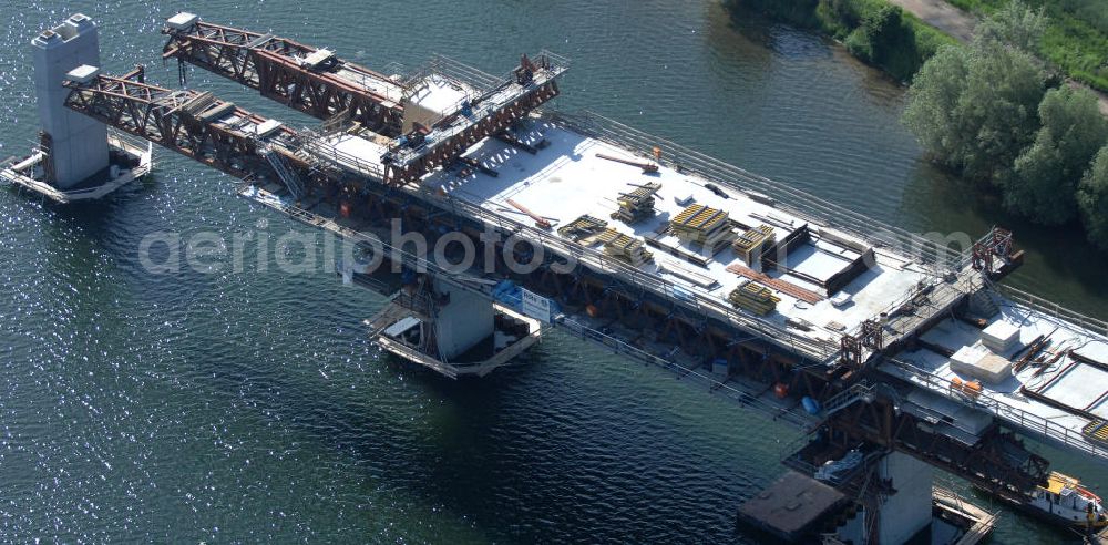 Aerial photograph Rattmannsdorf - Blick auf die Vorschub- Bauarbeiten an der Saale-Elster-Talbrücke über den Rattmannsdorfer See. Das Beton- Viadukt mit insgesamt 8, 5 Kilometern Länge wird teilweise mit großen Baugerüsten in so genannter Vor-Kopf-Bauweise errichtet, bei der zur Schonung der Umwelt alle Arbeitsschritte von der fertigten Brücke aus erfolgen und keine Baustraßen notwendig sind. Die ICE - Neubaustrecke im Projekt VDE 8 Nürnberg-Berlin der Deutschen Bahn soll 2015 in Betrieb gehen und wird das bisher längste Brückenbauwerk Deutschlands sein. Bauausführende Firmen sind die Hochtief Construction AG, Adam Hörnig, Gerdum und Breuer; Franki Grundbau; Doka Schalungstechniker; BBV Vorspanntechnik; Röro Traggerüstsysteme; Oevermann Hoch- und Tiefbau, Teupe & Söhne Gerüstbau GmbH, Alpine Bau und Arcelormittal. View of the construction of the Saale-Elster Viaduct on the Rattmannsdorfer lake.