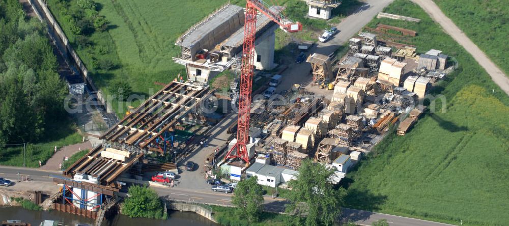 Rattmannsdorf from above - Blick auf die Vorschub- Bauarbeiten an der Saale-Elster-Talbrücke über den Rattmannsdorfer See. Das Beton- Viadukt mit insgesamt 8, 5 Kilometern Länge wird teilweise mit großen Baugerüsten in so genannter Vor-Kopf-Bauweise errichtet, bei der zur Schonung der Umwelt alle Arbeitsschritte von der fertigten Brücke aus erfolgen und keine Baustraßen notwendig sind. Die ICE - Neubaustrecke im Projekt VDE 8 Nürnberg-Berlin der Deutschen Bahn soll 2015 in Betrieb gehen und wird das bisher längste Brückenbauwerk Deutschlands sein. Bauausführende Firmen sind die Hochtief Construction AG, Adam Hörnig, Gerdum und Breuer; Franki Grundbau; Doka Schalungstechniker; BBV Vorspanntechnik; Röro Traggerüstsysteme; Oevermann Hoch- und Tiefbau, Teupe & Söhne Gerüstbau GmbH, Alpine Bau und Arcelormittal. View of the construction of the Saale-Elster Viaduct on the Rattmannsdorfer lake.