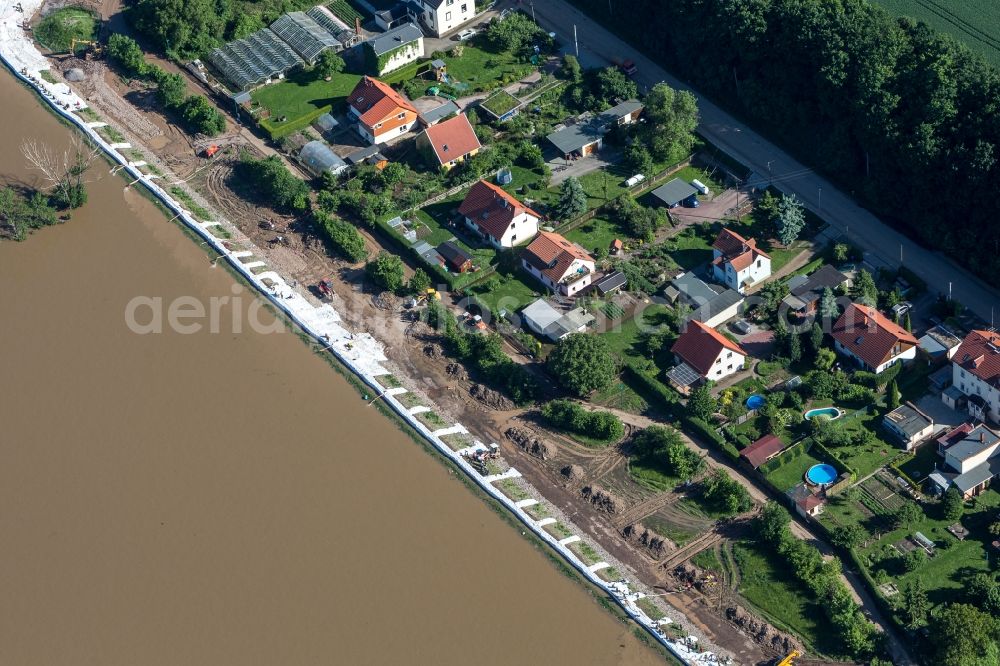 Coswig from the bird's eye view: Sandbags are used by helpers to strengthen a wall on the north shore of the Elbe river. They use sandbag damming with the help of heavy machinery