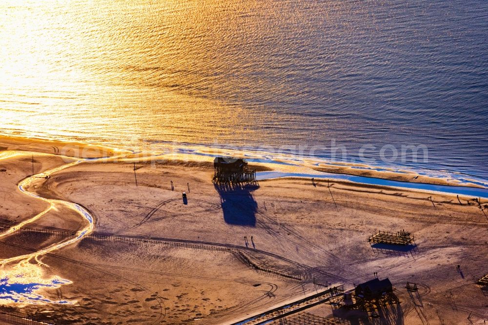 Aerial photograph Sankt Peter-Ording - Sandy beach landscape on the North Sea coast Pile dwellings restaurants - restaurants in Sankt Peter-Ording in the afterglow with long shadows in Schleswig-Holstein