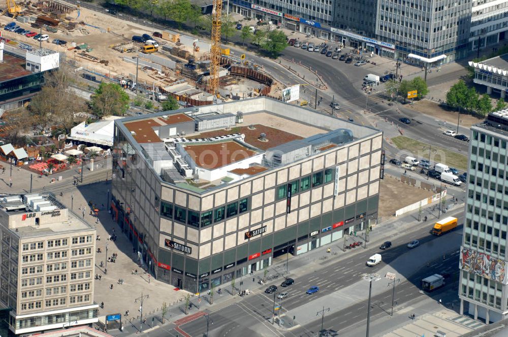 Aerial photograph Berlin - Blick auf den mit 10.000 Quadratmeter Verkaufsfläche größten Saturn-Markt Deutschlands. Das Elektronik-Unternehmen bezog das neue Geschäftshaus direkt auf dem Platz nahe der Kreuzung Alexan derstraße / Karl-Marx-Allee. Im Hintergrund entsteht ein Parkhaus. View to the largest Saturn market in Germany with 10.000 square meters sales area. The media company moved to the new buisnes building at the Alexanderplatz, near the crossroad Alexan derstraße/ Karl-Marx-Allee. In the backgorund is the pbuilding area of an parking area.Kontakt: