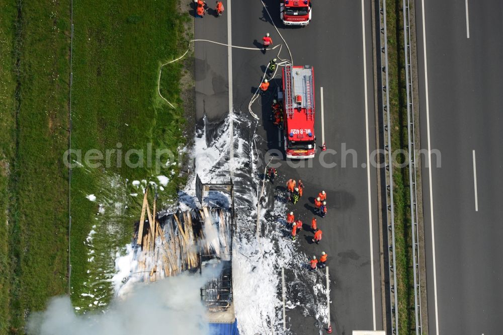 Aerial image Hollenstedt - Foam carpet-fighting operations of a fire department in a truck-fire-fire on the motorway Autobahn A1 - E22 at Hollenstedt in the state of Lower Saxony