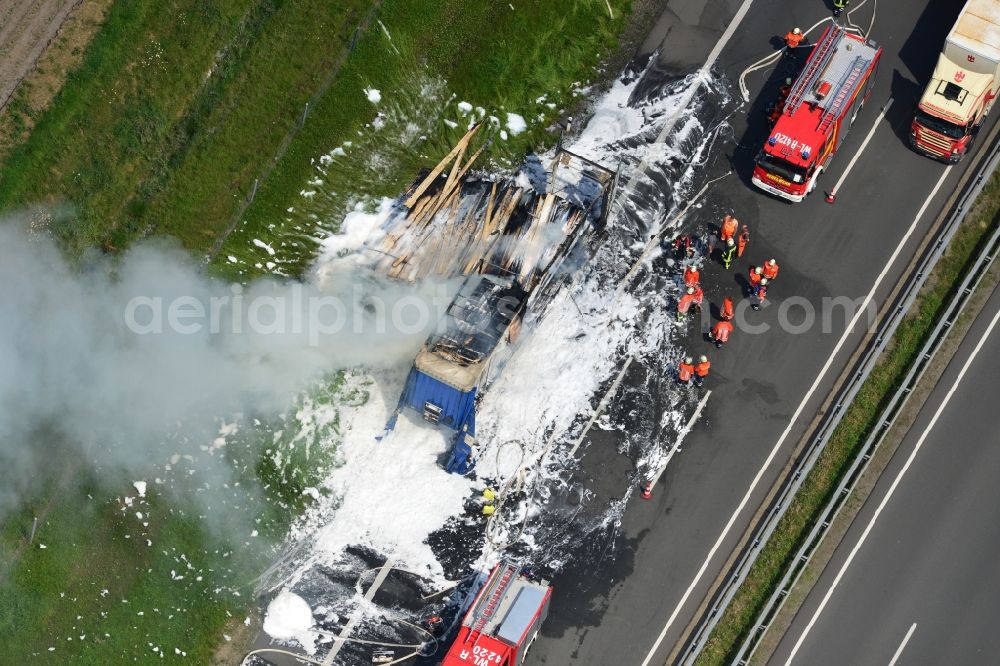 Aerial photograph Hollenstedt - Foam carpet-fighting operations of a fire department in a truck-fire-fire on the motorway Autobahn A1 - E22 at Hollenstedt in the state of Lower Saxony