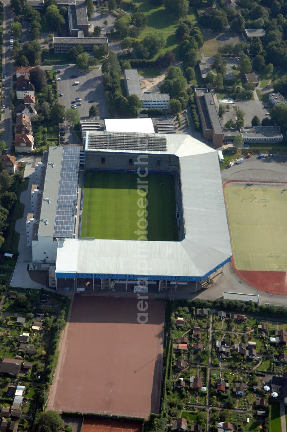 Bielefeld from above - Die Schüco Arena, auch Bielefelder Alm oder Alm-Stadion genannt, im Grundbuch eingetragen als Stadion an der Melanchthonstraße, ist die Wettkampfstätte des Deutschen Sportclubs Arminia Bielefeld. Das Stadion an der Melanchthonstraße, dessen Namensrechte am 13. Januar 2004 an die Firma Schüco International KG vergeben wurden, bietet 27.300 Zuschauern Platz und ist im Besitz des Vereins, der es ohne öffentliche Zuschüsse betreibt. Kontakt DSC Arminia Bielefeld GmbH & Co. KGaA: Tel. +49(0)521 966 110, Email: kontakt@arminia-bielefeld.de; Kontakt Schüco International KG: Tel. +49(0)521 7830, Email: info@schueco.com