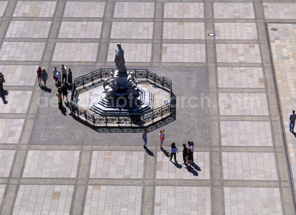 Aerial photograph Berlin - Blick auf den Schillerbrunnen auf dem Gendarmenmarkt, Markgrafenstraße, vor dem Schauspielhaus in Berlin, entstanden nach Plänen von Reinhold Begas 1871. Er besteht auf der zentralen Figur Goethes auf einem Sockel, umringt von vier sitzenden Frauenfiguren, welche allegorisch für die Lyrik, Dramatik, Philosophie und Geschichte stehen. Das Ensemble von Marmorfiguren wird umringt von einer schmiedeeisernen Einfriedung. Der Brunnen wurde 1936 demontiert. Die Begleitfiguren wurden eingelagert während die Zentralfigur Goethes im Lietzenseepark, Berlin Charlottenburg, aufgebaut wurde. 1986 wurden die Figuren wieder auf dem Gendarmenmarkt zusammengeführt.