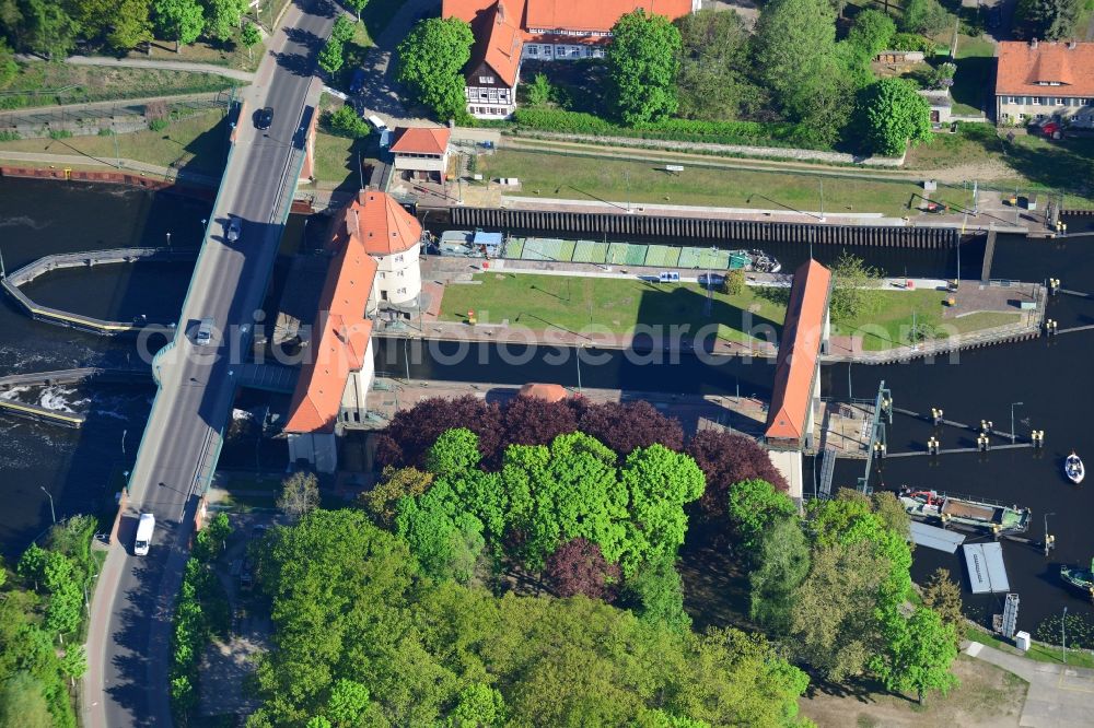 Kleinmachnow from the bird's eye view: Watergate Kleinmachnow in Kleinmachnow on the Teltow Canal in the state of Brandenburg. The facility is the most renowned building of the Teltow Canal. It is listed as a protected building. It was built in 1901 and is run by the Water and Ship Office of Berlin. The compound is located on Stahnsdorfer Damm and surrounded by forest