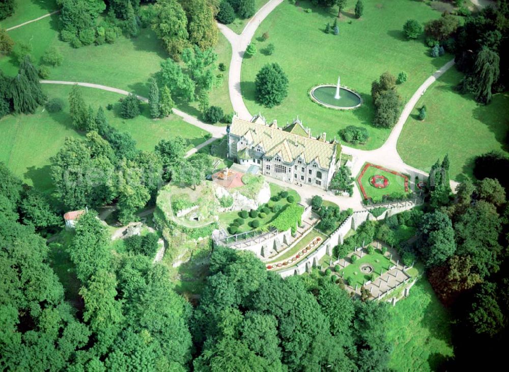 Aerial photograph Bad Liebenstein / Thüringen - 07.09.2002 Schloß Altenstein / Thüringen Nördlich von Bad Liebenstein liegt malerisch auf einem Bergplateau der ehemalige Sommersitz der Herzöge von Sachsen-Meiningen mit seiner weitläufigen Parkanlage. Vermutlich bestand schon im 6. Jahrhundert auf dem Altenstein eine von den Franken errichtete Befestigungsanlage zur Sicherung des Weges über den Thüringer Wald. Das Geschlecht vom Stein, das sich bis in das 10. Jahrhundert zurückverfolgen lässt, hatte später hier seinen Stammsitz. Nachdem der Thüringer Landgraf Friedrich der Ernsthafte 1346 Burg Altenstein erwarb, wurde sie zum Mittelpunkt eines Gerichtsbezirks. 1492-1722 war sie an das Geschlecht der Hund von Wenkheim mit ihr belehnt. Als die Burganlage 1733 durch Brandstiftung bis auf die Grundmauern niederbrannte, ließ Herzog Anton Ulrich von Sachsen-Meiningen durch den italienischen Baumeister Alessandro Rossini ein schlichtes barockes Schloss auf dem Altenstein errichten.