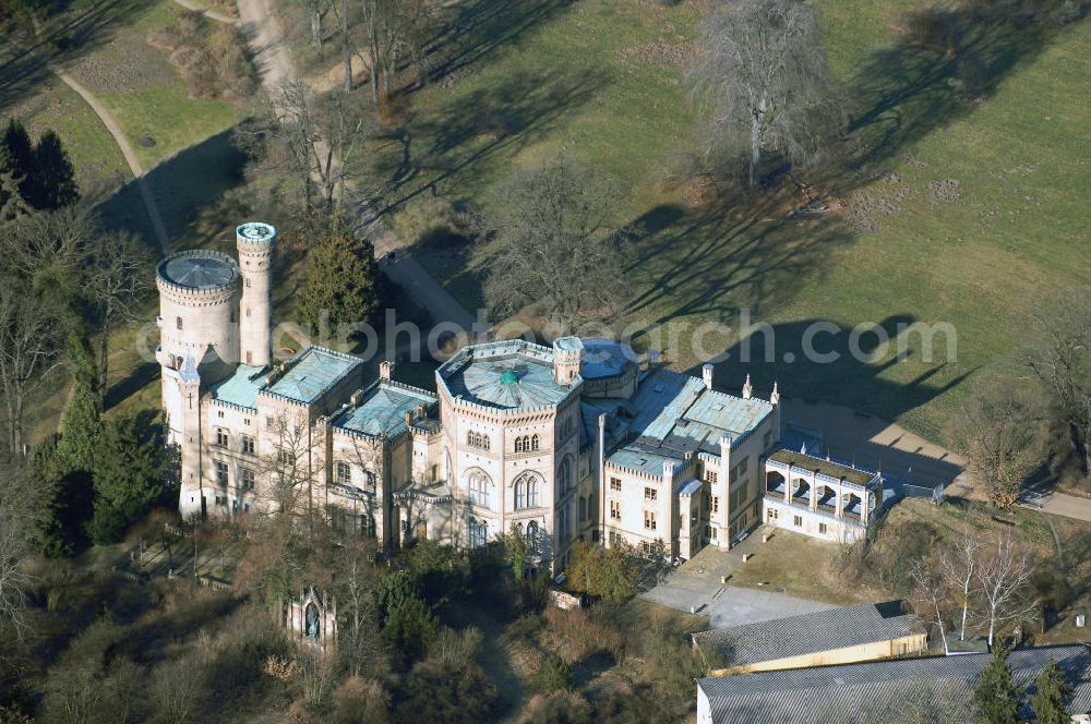 Aerial photograph Potsdam - Schloss Babelsberg liegt im gleichnamigen Park und Stadtteil der brandenburgischen Landeshauptstadt Potsdam. Über fünfzig Jahre war es der Sommersitz des Prinzen Wilhelm, dem späteren Kaiser Wilhelm I. und seiner aus dem Haus Sachsen-Weimar stammenden Gemahlin Augusta. Das im Stil der englischen Gotik gestaltete Gebäude wurde in den Jahren 1835-1849 in zwei Bauphasen errichtet. Den Auftrag zur Planung erhielten die Architekten Karl Friedrich Schinkel, Ludwig Persius und Johann Heinrich Strack.Bereits Jahre zuvor strebte Prinz Wilhelm den Bau eines eigenen Sommerschlosses an. Nach langem Zögern genehmigte König Friedrich Wilhelm III. 1833 seinem zweitältesten Sohn einen Neubau auf dem Babelsberg. Noch im selben Jahr begann Karl Friedrich Schinkel mit der Planung. Ihm lagen Entwurfszeichnungen eines gotisch erscheinenden Schlosses vor, die schon 1831 von seinem Meisterschüler Ludwig Persius für das Prinzenpaar erstellt wurden. Neben den klaren Formen des Klassizismus entsprach auch der gotische Baustil englischer Herkunft dem Zeitgeschmack, vermischt mit der verklärten Sicht auf das Mittelalter. In der romantischen Einstellung wurden Burgen als Symbole einer vereinten deutschen Nation angesehen.Nach dem Tod Wilhelms I. 1888 bevorzugten die kaiserlichen Nachfolger an dere Schlösser als Wohnsitz. Das Mobiliar ging durch Plünderungen nach 1945 verloren. Ab 1953 nutzte die Akademie für Staats- und Rechtswissenschaften der DDR einige Räume. Die Hörsäle befanden sich in Neubauten aus den 1950er Jahren hinter dem Schloss, die heute von der Universität Potsdam genutzt werden. Ab 1970 beherbergte das Gebäude ein Museum für Ur- und Frühgeschichte. Nach der Wende wurde der Schlossbau ab 1992 für museale Zwecke hergerichtet.Schloss Babelsberg steht unter der Verwaltung der Stiftung Preußische Schlösser und Gärten Berlin-Brandenburg und steht als Weltkulturerbe innerhalb des Gesamtensembles Potsdam unter dem Schutz der UNESCO.