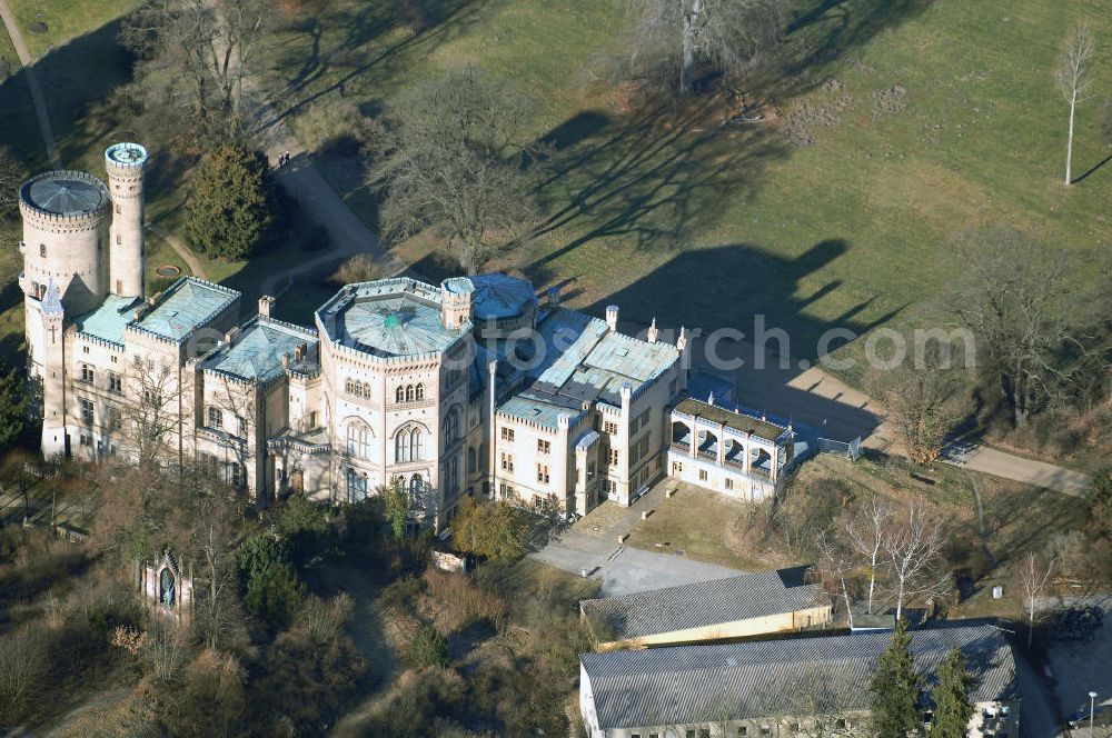 Potsdam from above - Schloss Babelsberg liegt im gleichnamigen Park und Stadtteil der brandenburgischen Landeshauptstadt Potsdam. Über fünfzig Jahre war es der Sommersitz des Prinzen Wilhelm, dem späteren Kaiser Wilhelm I. und seiner aus dem Haus Sachsen-Weimar stammenden Gemahlin Augusta. Das im Stil der englischen Gotik gestaltete Gebäude wurde in den Jahren 1835-1849 in zwei Bauphasen errichtet. Den Auftrag zur Planung erhielten die Architekten Karl Friedrich Schinkel, Ludwig Persius und Johann Heinrich Strack.Bereits Jahre zuvor strebte Prinz Wilhelm den Bau eines eigenen Sommerschlosses an. Nach langem Zögern genehmigte König Friedrich Wilhelm III. 1833 seinem zweitältesten Sohn einen Neubau auf dem Babelsberg. Noch im selben Jahr begann Karl Friedrich Schinkel mit der Planung. Ihm lagen Entwurfszeichnungen eines gotisch erscheinenden Schlosses vor, die schon 1831 von seinem Meisterschüler Ludwig Persius für das Prinzenpaar erstellt wurden. Neben den klaren Formen des Klassizismus entsprach auch der gotische Baustil englischer Herkunft dem Zeitgeschmack, vermischt mit der verklärten Sicht auf das Mittelalter. In der romantischen Einstellung wurden Burgen als Symbole einer vereinten deutschen Nation angesehen.Nach dem Tod Wilhelms I. 1888 bevorzugten die kaiserlichen Nachfolger an dere Schlösser als Wohnsitz. Das Mobiliar ging durch Plünderungen nach 1945 verloren. Ab 1953 nutzte die Akademie für Staats- und Rechtswissenschaften der DDR einige Räume. Die Hörsäle befanden sich in Neubauten aus den 1950er Jahren hinter dem Schloss, die heute von der Universität Potsdam genutzt werden. Ab 1970 beherbergte das Gebäude ein Museum für Ur- und Frühgeschichte. Nach der Wende wurde der Schlossbau ab 1992 für museale Zwecke hergerichtet.Schloss Babelsberg steht unter der Verwaltung der Stiftung Preußische Schlösser und Gärten Berlin-Brandenburg und steht als Weltkulturerbe innerhalb des Gesamtensembles Potsdam unter dem Schutz der UNESCO.