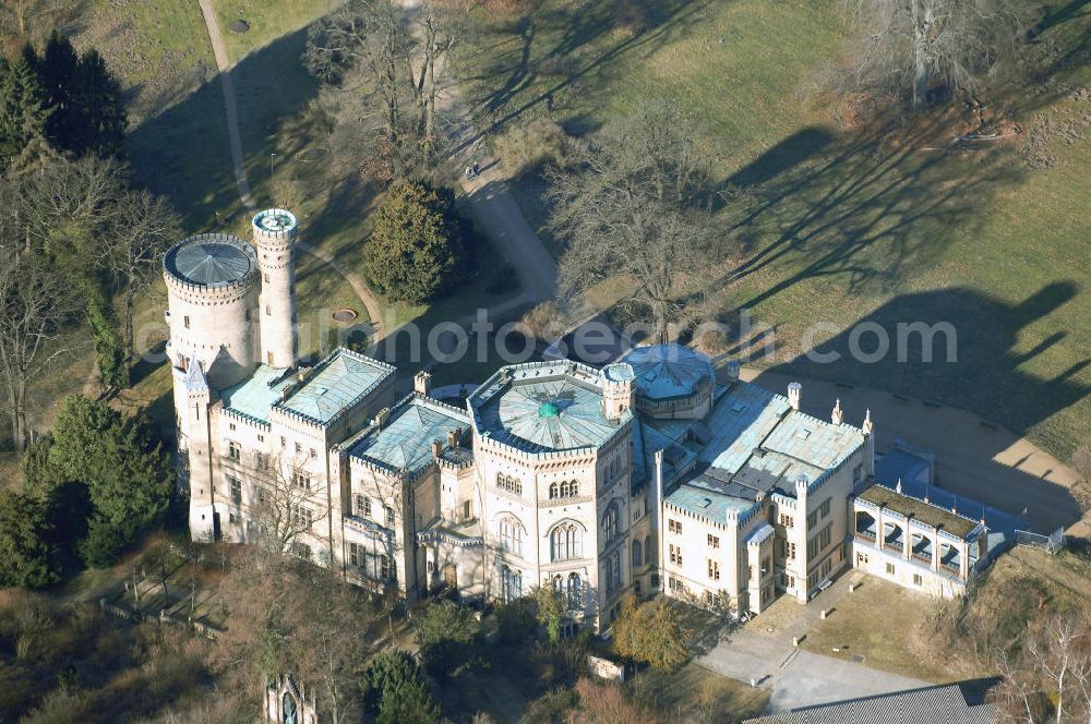 Potsdam from the bird's eye view: Schloss Babelsberg liegt im gleichnamigen Park und Stadtteil der brandenburgischen Landeshauptstadt Potsdam. Über fünfzig Jahre war es der Sommersitz des Prinzen Wilhelm, dem späteren Kaiser Wilhelm I. und seiner aus dem Haus Sachsen-Weimar stammenden Gemahlin Augusta. Das im Stil der englischen Gotik gestaltete Gebäude wurde in den Jahren 1835-1849 in zwei Bauphasen errichtet. Den Auftrag zur Planung erhielten die Architekten Karl Friedrich Schinkel, Ludwig Persius und Johann Heinrich Strack.Bereits Jahre zuvor strebte Prinz Wilhelm den Bau eines eigenen Sommerschlosses an. Nach langem Zögern genehmigte König Friedrich Wilhelm III. 1833 seinem zweitältesten Sohn einen Neubau auf dem Babelsberg. Noch im selben Jahr begann Karl Friedrich Schinkel mit der Planung. Ihm lagen Entwurfszeichnungen eines gotisch erscheinenden Schlosses vor, die schon 1831 von seinem Meisterschüler Ludwig Persius für das Prinzenpaar erstellt wurden. Neben den klaren Formen des Klassizismus entsprach auch der gotische Baustil englischer Herkunft dem Zeitgeschmack, vermischt mit der verklärten Sicht auf das Mittelalter. In der romantischen Einstellung wurden Burgen als Symbole einer vereinten deutschen Nation angesehen.Nach dem Tod Wilhelms I. 1888 bevorzugten die kaiserlichen Nachfolger an dere Schlösser als Wohnsitz. Das Mobiliar ging durch Plünderungen nach 1945 verloren. Ab 1953 nutzte die Akademie für Staats- und Rechtswissenschaften der DDR einige Räume. Die Hörsäle befanden sich in Neubauten aus den 1950er Jahren hinter dem Schloss, die heute von der Universität Potsdam genutzt werden. Ab 1970 beherbergte das Gebäude ein Museum für Ur- und Frühgeschichte. Nach der Wende wurde der Schlossbau ab 1992 für museale Zwecke hergerichtet.Schloss Babelsberg steht unter der Verwaltung der Stiftung Preußische Schlösser und Gärten Berlin-Brandenburg und steht als Weltkulturerbe innerhalb des Gesamtensembles Potsdam unter dem Schutz der UNESCO.