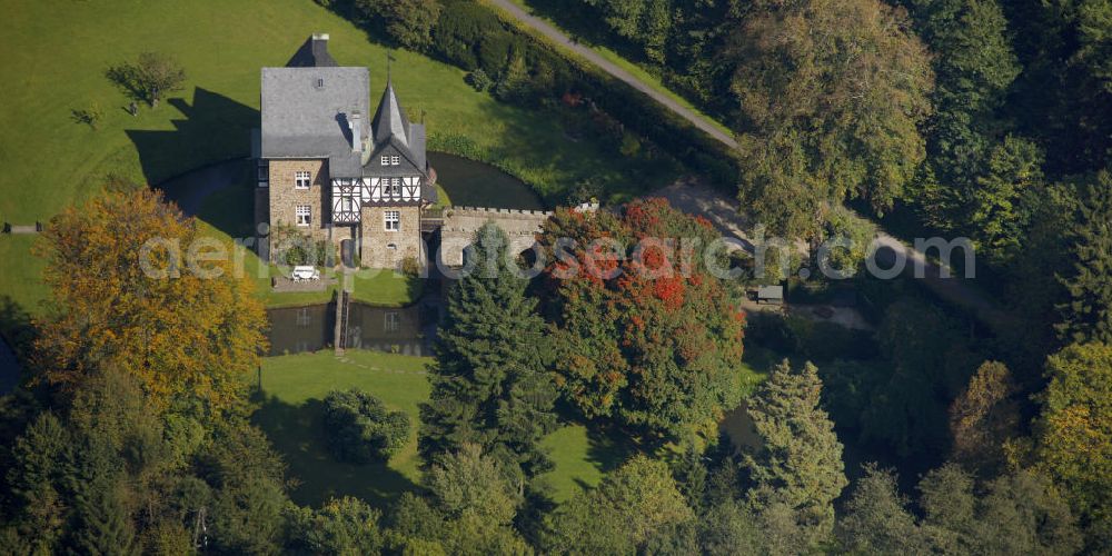 Aerial image Meinerzhagen - Herbstlicher Blick auf das Schloss Badinghagen - es ist ein Wasserschloss, das dicht an der Grenze zum Bergischen Land südlich von Meinerzhagen steht und 1902 stark modernisiert wurde. Seine Gräften werden von der Agger gespeist. Im Werdener Propsteiregister wurde das Schloss im Jahr 1160 als Lehnsgut erstmals genannt. Im Besitz der Badinghagens ist es nachweislich seit dem Jahr 1363. Nach Aussterben der Familie ging es 1509 über Friedrich von Karthausen durch Verkauf im Jahr 1642 an Friedrich von Neuhoff. Drei Generationen später war Conrad Caspar von Nagel, ein Sohn der Erbtochter, Eigentümer des Schlosses Badinghagen. Die heutige, mittlerweile mehrmals umgebaute Anlage hat nur ungefähr den Grundriss des früheren Bauwerks, das etwa Mitte des 17. Jahrhunderts die Eheleute Engelbert von Neuhoff und Anna Margarethe von Scheid errichten ließen.