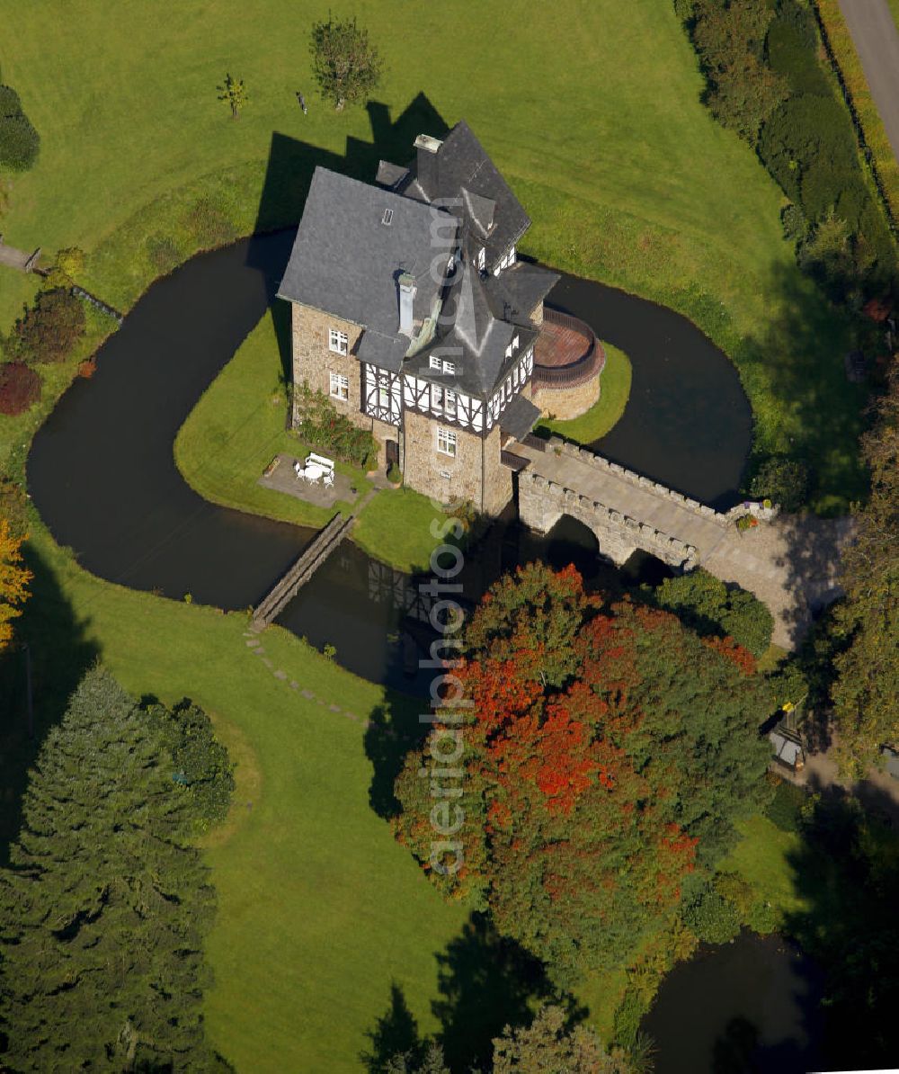 Meinerzhagen from above - Herbstlicher Blick auf das Schloss Badinghagen - es ist ein Wasserschloss, das dicht an der Grenze zum Bergischen Land südlich von Meinerzhagen steht und 1902 stark modernisiert wurde. Seine Gräften werden von der Agger gespeist. Im Werdener Propsteiregister wurde das Schloss im Jahr 1160 als Lehnsgut erstmals genannt. Im Besitz der Badinghagens ist es nachweislich seit dem Jahr 1363. Nach Aussterben der Familie ging es 1509 über Friedrich von Karthausen durch Verkauf im Jahr 1642 an Friedrich von Neuhoff. Drei Generationen später war Conrad Caspar von Nagel, ein Sohn der Erbtochter, Eigentümer des Schlosses Badinghagen. Die heutige, mittlerweile mehrmals umgebaute Anlage hat nur ungefähr den Grundriss des früheren Bauwerks, das etwa Mitte des 17. Jahrhunderts die Eheleute Engelbert von Neuhoff und Anna Margarethe von Scheid errichten ließen.