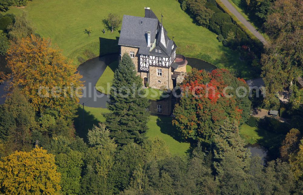 Aerial image Meinerzhagen - Herbstlicher Blick auf das Schloss Badinghagen - es ist ein Wasserschloss, das dicht an der Grenze zum Bergischen Land südlich von Meinerzhagen steht und 1902 stark modernisiert wurde. Seine Gräften werden von der Agger gespeist. Im Werdener Propsteiregister wurde das Schloss im Jahr 1160 als Lehnsgut erstmals genannt. Im Besitz der Badinghagens ist es nachweislich seit dem Jahr 1363. Nach Aussterben der Familie ging es 1509 über Friedrich von Karthausen durch Verkauf im Jahr 1642 an Friedrich von Neuhoff. Drei Generationen später war Conrad Caspar von Nagel, ein Sohn der Erbtochter, Eigentümer des Schlosses Badinghagen. Die heutige, mittlerweile mehrmals umgebaute Anlage hat nur ungefähr den Grundriss des früheren Bauwerks, das etwa Mitte des 17. Jahrhunderts die Eheleute Engelbert von Neuhoff und Anna Margarethe von Scheid errichten ließen.