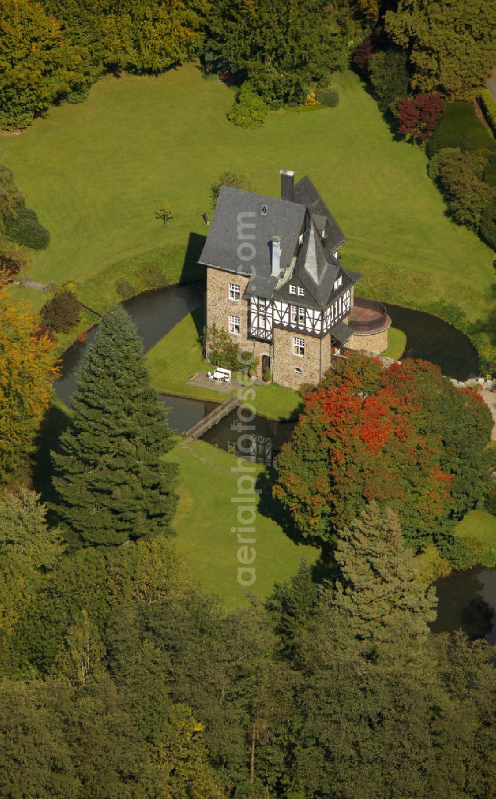 Aerial photograph Meinerzhagen - Herbstlicher Blick auf das Schloss Badinghagen - es ist ein Wasserschloss, das dicht an der Grenze zum Bergischen Land südlich von Meinerzhagen steht und 1902 stark modernisiert wurde. Seine Gräften werden von der Agger gespeist. Im Werdener Propsteiregister wurde das Schloss im Jahr 1160 als Lehnsgut erstmals genannt. Im Besitz der Badinghagens ist es nachweislich seit dem Jahr 1363. Nach Aussterben der Familie ging es 1509 über Friedrich von Karthausen durch Verkauf im Jahr 1642 an Friedrich von Neuhoff. Drei Generationen später war Conrad Caspar von Nagel, ein Sohn der Erbtochter, Eigentümer des Schlosses Badinghagen. Die heutige, mittlerweile mehrmals umgebaute Anlage hat nur ungefähr den Grundriss des früheren Bauwerks, das etwa Mitte des 17. Jahrhunderts die Eheleute Engelbert von Neuhoff und Anna Margarethe von Scheid errichten ließen.