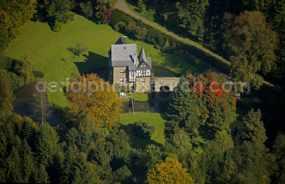 Meinerzhagen from above - Herbstlicher Blick auf das Schloss Badinghagen - es ist ein Wasserschloss, das dicht an der Grenze zum Bergischen Land südlich von Meinerzhagen steht und 1902 stark modernisiert wurde. Seine Gräften werden von der Agger gespeist. Im Werdener Propsteiregister wurde das Schloss im Jahr 1160 als Lehnsgut erstmals genannt. Im Besitz der Badinghagens ist es nachweislich seit dem Jahr 1363. Nach Aussterben der Familie ging es 1509 über Friedrich von Karthausen durch Verkauf im Jahr 1642 an Friedrich von Neuhoff. Drei Generationen später war Conrad Caspar von Nagel, ein Sohn der Erbtochter, Eigentümer des Schlosses Badinghagen. Die heutige, mittlerweile mehrmals umgebaute Anlage hat nur ungefähr den Grundriss des früheren Bauwerks, das etwa Mitte des 17. Jahrhunderts die Eheleute Engelbert von Neuhoff und Anna Margarethe von Scheid errichten ließen.