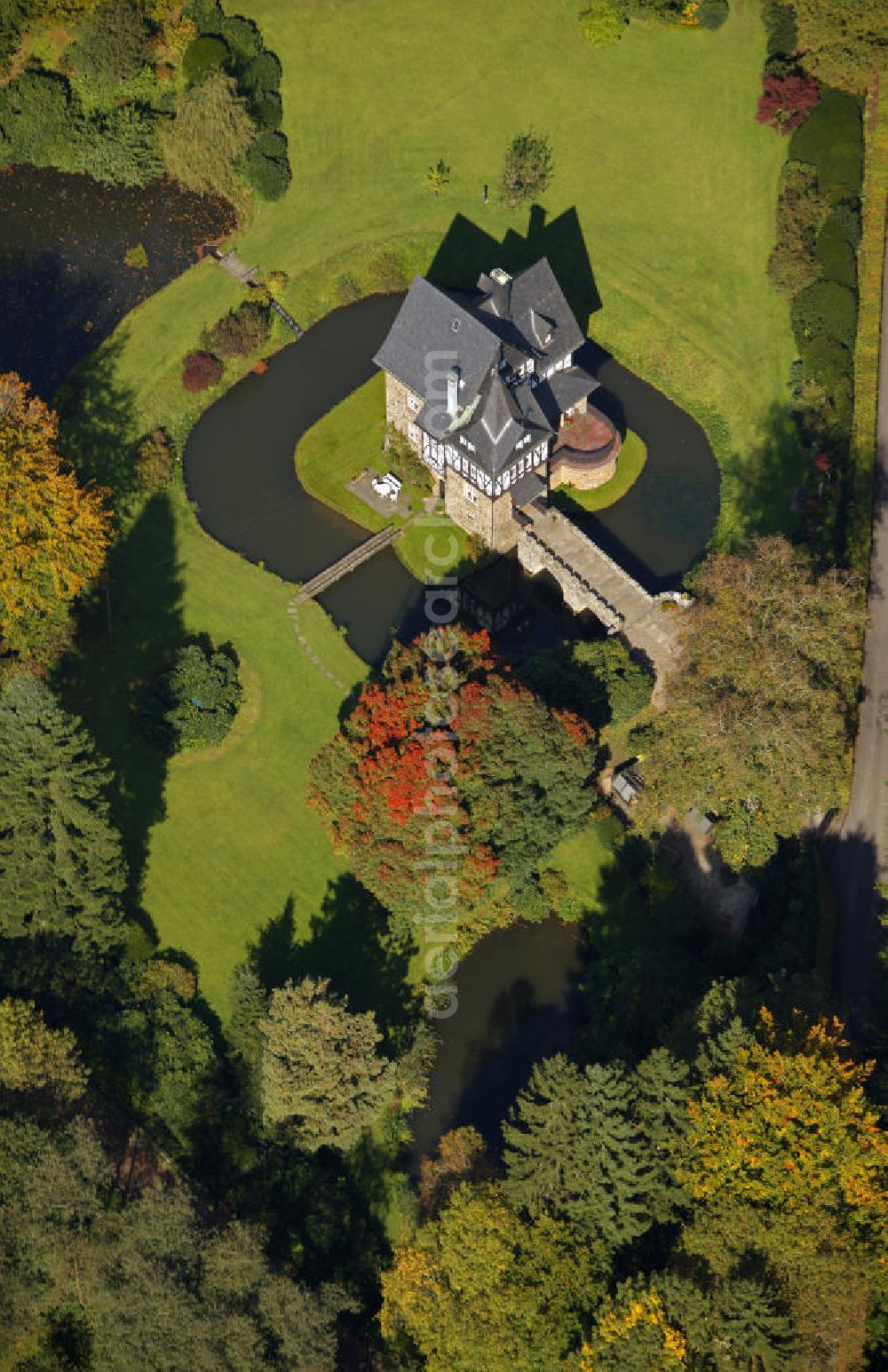 Aerial image Meinerzhagen - Herbstlicher Blick auf das Schloss Badinghagen - es ist ein Wasserschloss, das dicht an der Grenze zum Bergischen Land südlich von Meinerzhagen steht und 1902 stark modernisiert wurde. Seine Gräften werden von der Agger gespeist. Im Werdener Propsteiregister wurde das Schloss im Jahr 1160 als Lehnsgut erstmals genannt. Im Besitz der Badinghagens ist es nachweislich seit dem Jahr 1363. Nach Aussterben der Familie ging es 1509 über Friedrich von Karthausen durch Verkauf im Jahr 1642 an Friedrich von Neuhoff. Drei Generationen später war Conrad Caspar von Nagel, ein Sohn der Erbtochter, Eigentümer des Schlosses Badinghagen. Die heutige, mittlerweile mehrmals umgebaute Anlage hat nur ungefähr den Grundriss des früheren Bauwerks, das etwa Mitte des 17. Jahrhunderts die Eheleute Engelbert von Neuhoff und Anna Margarethe von Scheid errichten ließen.