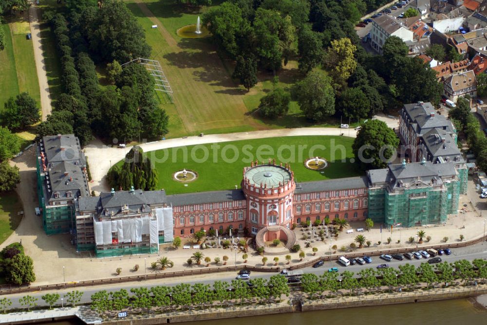 Aerial photograph Wiesbaden - Im Blick das Schloss Biebrich während der Restaurierung. Fürst Georg August Samuel von Nassau-Idstein ließ sein 1701 begonnenes Gartenhaus durch Julius Ludwig Rothweil bis 1703 zu einem Wohnschlösschen ausbauen, in den Folgejahren weiter östlich ein identisches Gegenstück errichten und ab 1708 beide Bauteile durch einen Mittelbau mit Rotunde verbinden. Seit 1929 findet jährlich an Pfingsten das Internationale Reitturnier im Schlosspark statt. Das Schloss, das im Besitz des Landes Hessen ist, wird vom Hessischen Immobilienmanagement verwaltet. Es dient als repräsentatives Gebäude für Empfänge der Landesregierung und als Standesamt. Außerdem sind mehrere Behörden im Schloss untergebracht, darunter das Hessische Landesamt für Denkmalpflege. Seit dem Wiederaufbau des Ostflügels 1982 befindet sich dort die staatliche Filmbewertungsstelle Wiesbaden, eine Einrichtung der Bundesländer, dessen Vorführsaal als Veranstaltungsort für Filme im Schloss genutzt wird.