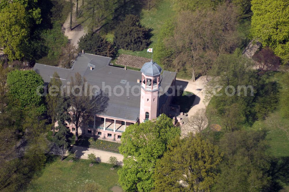 Aerial photograph Berlin - Es wurde 1868 als spätklassizistische Turmvilla auf dem Gelände eines ehemaligen Rittergutes erbaut. Zu den Besitzern des Schlosses zählten unter an derem Werner und Wilhelm von Siemens. Wilhelm ließ den Schlosspark zwischen 1891 und 1898 auf 14 Hektar erweitern und durch den Gartenarchitekten Albert Brodersen als Landschaftspark gestalten. Das Schloss, dem die Architekten Martin Gropius, Heino Schmieden und später Theodor Astfalck sein einst markantes Aussehen verliehen, ging 1927 in den Besitz der Stadt Berlin über und ist seitdem einer stetigen Vernachlässigung ausgesetzt worden. Ein Brand im Jahre 1945 vernichtete das Obergeschoss, das bislang nicht wieder aufgebaut wurde. Seit 1979 stehen der alte Herrensitz, der Schlosspark und der historische Biesdorfer Ortskern unter Denkmalschutz. Als besonderes Schutzgut gilt die für den Berliner Raum einmalige Fassadenausführung in eingefärbtem Romanzementmörtel (Kunststeinfassade, ausgeführt durch den Stukkateurmeister H.Beyerhaus, Berlin, als „meine erste Fassade in Zementguß“). Das Biesdorfer Schloss wurde in den vergangenen Jahren und Jahrzehnten als Freizeiteinrichtung und seit 1994 als sozial-kulturelles Zentrum genutzt.