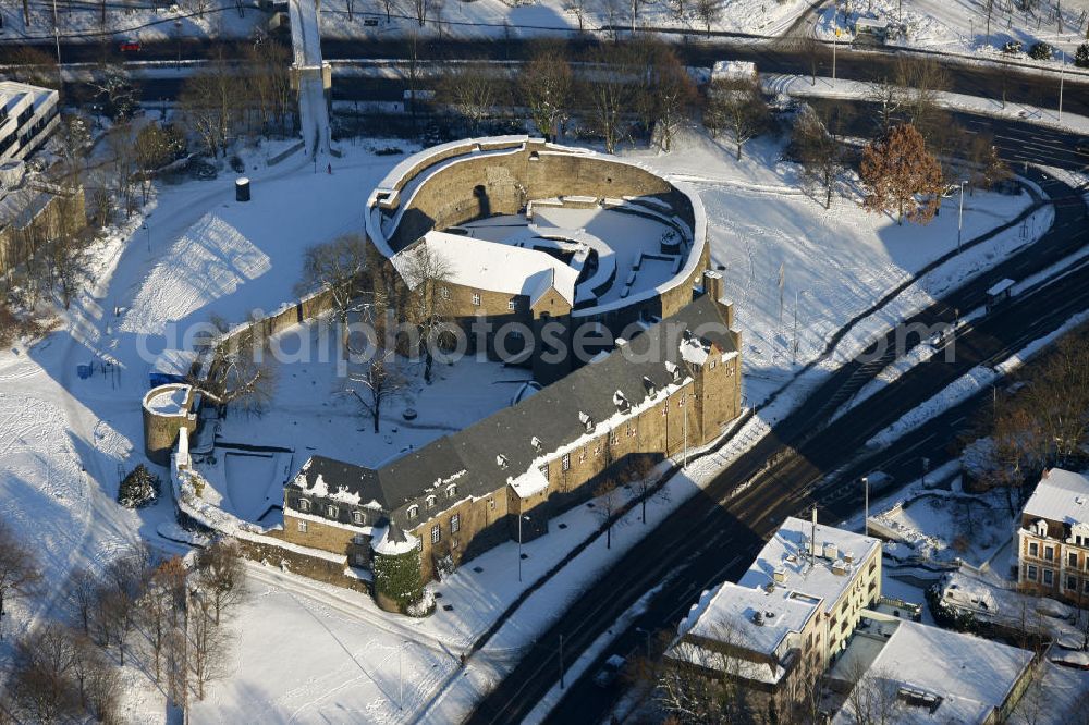 Aerial image Mülheim - Blick auf das winterlich, schneebedeckte Schloss Broich der Stadt Mülheim an der Ruhr. Die Befestigungsanlage der älteste, frühmittelalterlich erhaltenen Wehrbau der späten Karolingerzeit, nördlich der Alpen. Heute werden die Räumlichkeiten für städtische Empfänge und standesamtliche Trauungen genutzt. View of the castle Broich in Mülheim at the Ruhr, in the winter. The fortification of the oldest preserved medieval fortress of the early late Carolingian period, north of the Alps. Today, the premises are used for urban receptions and civil weddings.