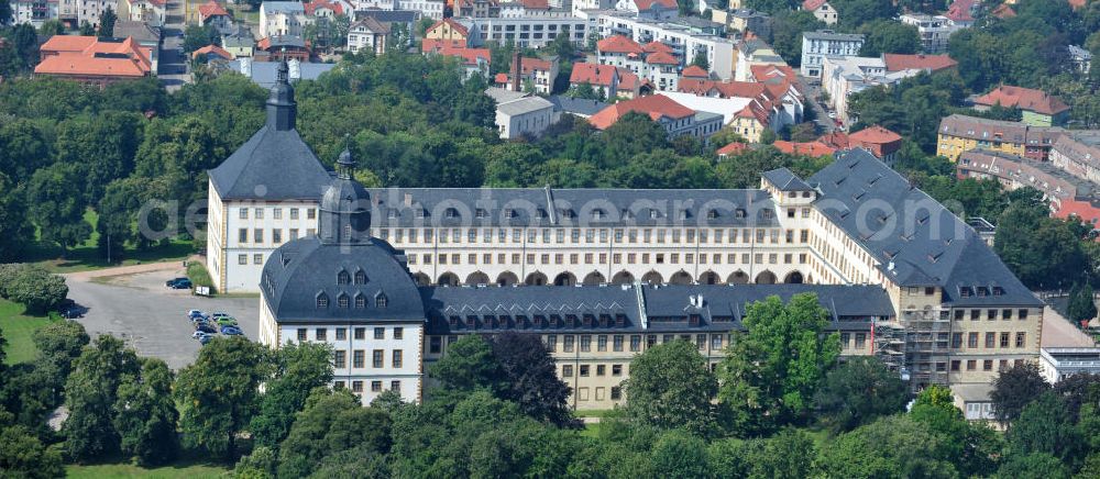 Gotha from above - Blick auf das Schloss Friedenstein. Das Schloß im Barockstil wurde zwischen 1643 und 1656 durch Herzog Ernst I. erbaut. Sowohl äußerlich als auch die Räume des Schlosses sind weitgehend original erhalten und stehen unter Denkmalschutz. Innerhalb der Räumlichkeiten befinden sich schon seit Jahrhunderten eine Bibliothek, ein Archiv, Kunstsammlungen und ein Theater, sowie eine Kirche, aus diesem Grund wird das Schloss auch die Kunstkammer Thüringens genannt.Im Westturm des Schlosses befindet sich mit dem Ekhof-Theater eines der ältesten dauerhaft bespielten Theater Deutschlands. Gegründet wurde es durch Friedrich I. von Sachsen-Gotha-Altenburg (1646-1691). Das Theater besitzt die einzige vollständige erhaltene Bühnenmaschinerie des Barock. Friedenstein Castle in Thuringia.