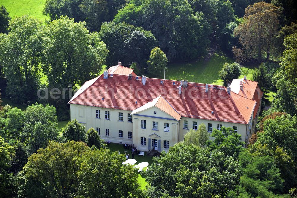 Aerial image Hoppenrade - Schloss Hoppenrade ist eine der bedeutenden barocken Anlagen in Brandenburg. Es wurde auf den Fundamenten einer Wasserburg errichtet, die vermutlich Hans von Bredow in der zweiten Hälfte des 15. Jahrhunderts bauen ließ. 1723 wurde der Vorgängerbau abgetragen und anschließend das Herrenhaus als eingeschossige Dreiflügelanlage erbaut. Im rechten Seitenflügel wurde die Dorfkirche untergebracht. Heute ist die Immobilie -nach neuestem Stand ausgebaut- als Veranstaltungs- und Hochtzeitsschloß zu mieten. Hoppenrade Castle is one of the major baroque installations in Brandenburg.