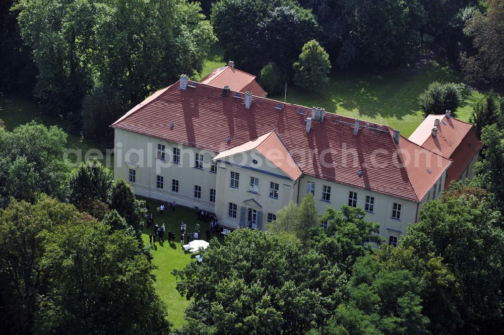 Aerial photograph Hoppenrade - Schloss Hoppenrade ist eine der bedeutenden barocken Anlagen in Brandenburg. Es wurde auf den Fundamenten einer Wasserburg errichtet, die vermutlich Hans von Bredow in der zweiten Hälfte des 15. Jahrhunderts bauen ließ. 1723 wurde der Vorgängerbau abgetragen und anschließend das Herrenhaus als eingeschossige Dreiflügelanlage erbaut. Im rechten Seitenflügel wurde die Dorfkirche untergebracht. Heute ist die Immobilie -nach neuestem Stand ausgebaut- als Veranstaltungs- und Hochtzeitsschloß zu mieten. Hoppenrade Castle is one of the major baroque installations in Brandenburg.