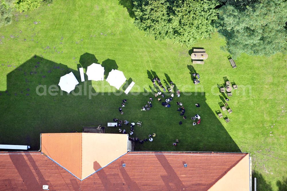 Hoppenrade from the bird's eye view: Schloss Hoppenrade ist eine der bedeutenden barocken Anlagen in Brandenburg. Es wurde auf den Fundamenten einer Wasserburg errichtet, die vermutlich Hans von Bredow in der zweiten Hälfte des 15. Jahrhunderts bauen ließ. 1723 wurde der Vorgängerbau abgetragen und anschließend das Herrenhaus als eingeschossige Dreiflügelanlage erbaut. Im rechten Seitenflügel wurde die Dorfkirche untergebracht. Heute ist die Immobilie -nach neuestem Stand ausgebaut- als Veranstaltungs- und Hochtzeitsschloß zu mieten. Hoppenrade Castle is one of the major baroque installations in Brandenburg.