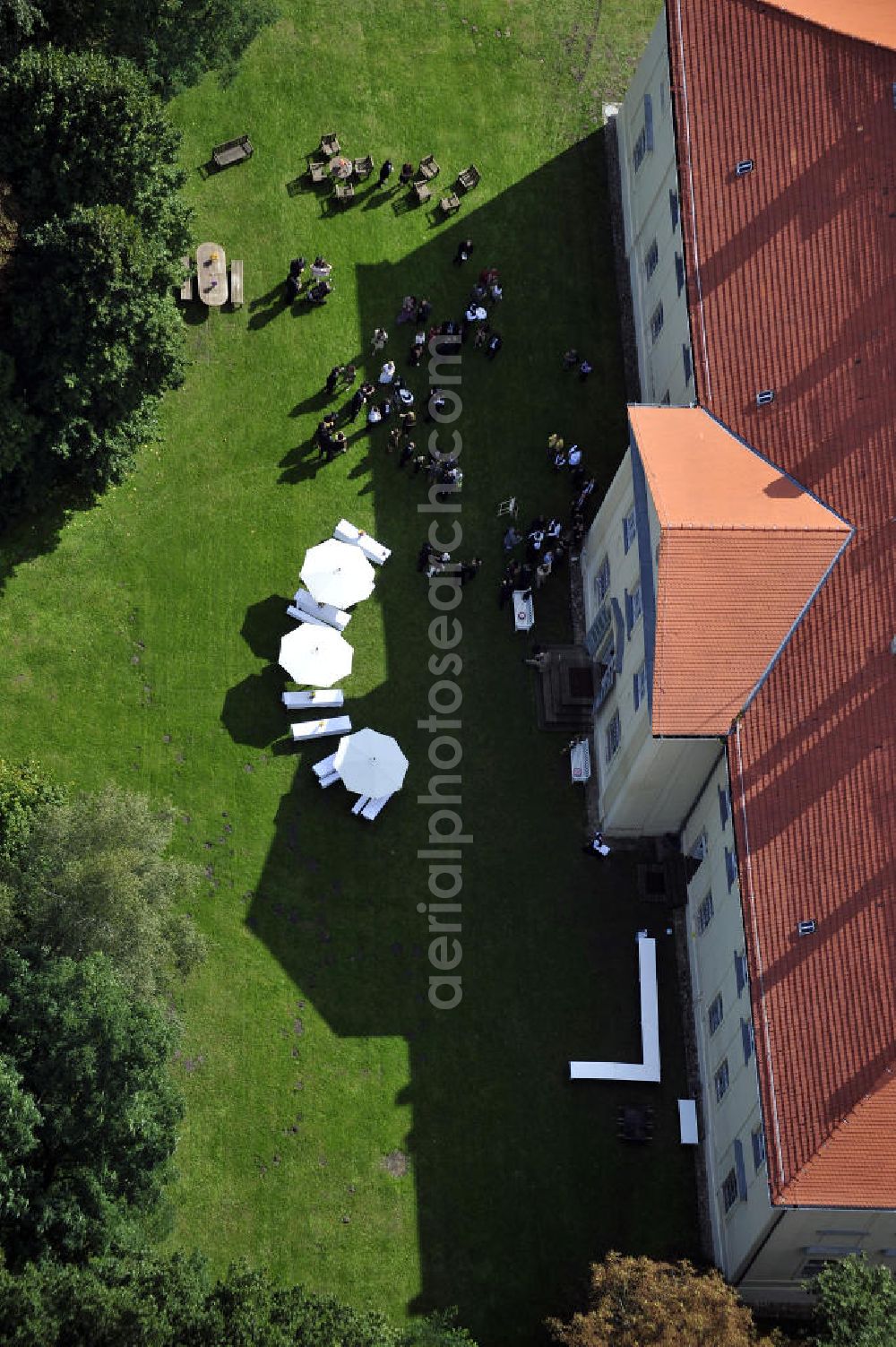 Aerial photograph Hoppenrade - Schloss Hoppenrade ist eine der bedeutenden barocken Anlagen in Brandenburg. Es wurde auf den Fundamenten einer Wasserburg errichtet, die vermutlich Hans von Bredow in der zweiten Hälfte des 15. Jahrhunderts bauen ließ. 1723 wurde der Vorgängerbau abgetragen und anschließend das Herrenhaus als eingeschossige Dreiflügelanlage erbaut. Im rechten Seitenflügel wurde die Dorfkirche untergebracht. Heute ist die Immobilie -nach neuestem Stand ausgebaut- als Veranstaltungs- und Hochtzeitsschloß zu mieten. Hoppenrade Castle is one of the major baroque installations in Brandenburg.