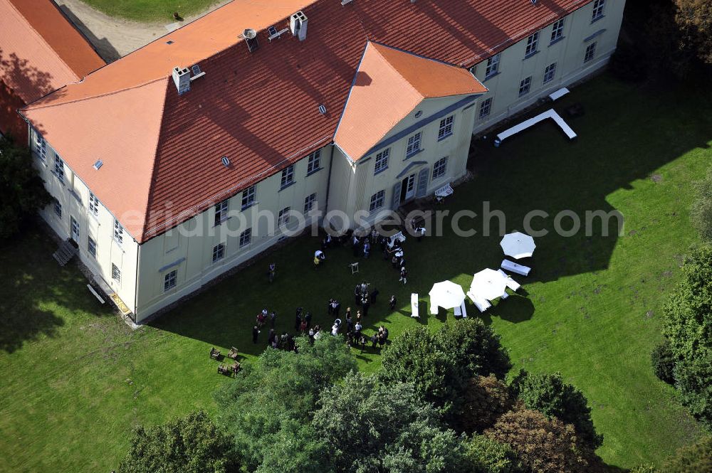 Hoppenrade from the bird's eye view: Schloss Hoppenrade ist eine der bedeutenden barocken Anlagen in Brandenburg. Es wurde auf den Fundamenten einer Wasserburg errichtet, die vermutlich Hans von Bredow in der zweiten Hälfte des 15. Jahrhunderts bauen ließ. 1723 wurde der Vorgängerbau abgetragen und anschließend das Herrenhaus als eingeschossige Dreiflügelanlage erbaut. Im rechten Seitenflügel wurde die Dorfkirche untergebracht. Heute ist die Immobilie -nach neuestem Stand ausgebaut- als Veranstaltungs- und Hochtzeitsschloß zu mieten. Hoppenrade Castle is one of the major baroque installations in Brandenburg.