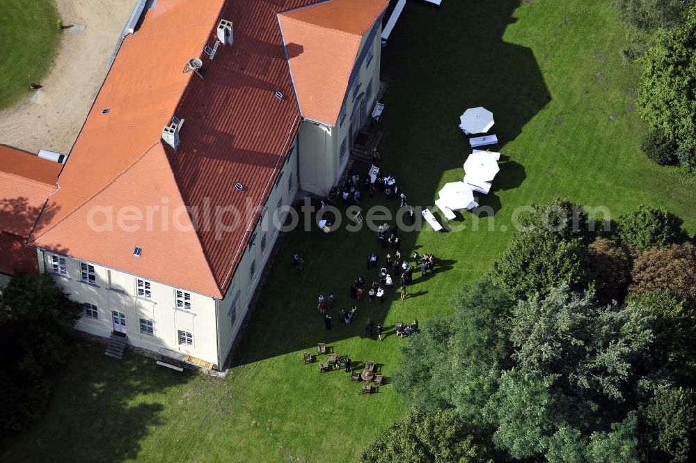 Aerial image Hoppenrade - Schloss Hoppenrade ist eine der bedeutenden barocken Anlagen in Brandenburg. Es wurde auf den Fundamenten einer Wasserburg errichtet, die vermutlich Hans von Bredow in der zweiten Hälfte des 15. Jahrhunderts bauen ließ. 1723 wurde der Vorgängerbau abgetragen und anschließend das Herrenhaus als eingeschossige Dreiflügelanlage erbaut. Im rechten Seitenflügel wurde die Dorfkirche untergebracht. Heute ist die Immobilie -nach neuestem Stand ausgebaut- als Veranstaltungs- und Hochtzeitsschloß zu mieten. Hoppenrade Castle is one of the major baroque installations in Brandenburg.