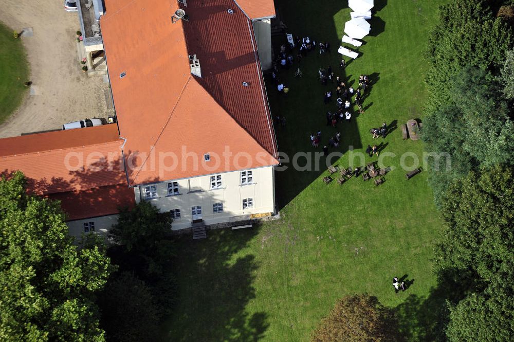 Aerial photograph Hoppenrade - Schloss Hoppenrade ist eine der bedeutenden barocken Anlagen in Brandenburg. Es wurde auf den Fundamenten einer Wasserburg errichtet, die vermutlich Hans von Bredow in der zweiten Hälfte des 15. Jahrhunderts bauen ließ. 1723 wurde der Vorgängerbau abgetragen und anschließend das Herrenhaus als eingeschossige Dreiflügelanlage erbaut. Im rechten Seitenflügel wurde die Dorfkirche untergebracht. Heute ist die Immobilie -nach neuestem Stand ausgebaut- als Veranstaltungs- und Hochtzeitsschloß zu mieten. Hoppenrade Castle is one of the major baroque installations in Brandenburg.