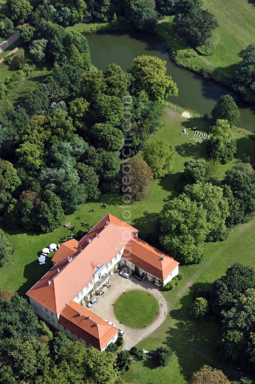 Hoppenrade from the bird's eye view: Schloss Hoppenrade ist eine der bedeutenden barocken Anlagen in Brandenburg. Es wurde auf den Fundamenten einer Wasserburg errichtet, die vermutlich Hans von Bredow in der zweiten Hälfte des 15. Jahrhunderts bauen ließ. 1723 wurde der Vorgängerbau abgetragen und anschließend das Herrenhaus als eingeschossige Dreiflügelanlage erbaut. Im rechten Seitenflügel wurde die Dorfkirche untergebracht. Heute ist die Immobilie -nach neuestem Stand ausgebaut- als Veranstaltungs- und Hochtzeitsschloß zu mieten. Hoppenrade Castle is one of the major baroque installations in Brandenburg.