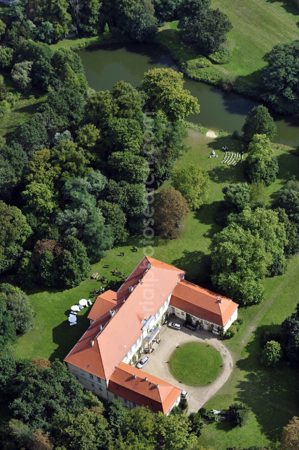 Aerial image Hoppenrade - Schloss Hoppenrade ist eine der bedeutenden barocken Anlagen in Brandenburg. Es wurde auf den Fundamenten einer Wasserburg errichtet, die vermutlich Hans von Bredow in der zweiten Hälfte des 15. Jahrhunderts bauen ließ. 1723 wurde der Vorgängerbau abgetragen und anschließend das Herrenhaus als eingeschossige Dreiflügelanlage erbaut. Im rechten Seitenflügel wurde die Dorfkirche untergebracht. Heute ist die Immobilie -nach neuestem Stand ausgebaut- als Veranstaltungs- und Hochtzeitsschloß zu mieten. Hoppenrade Castle is one of the major baroque installations in Brandenburg.