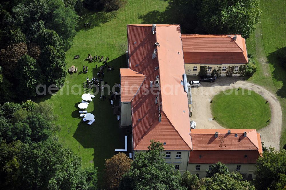 Aerial photograph Hoppenrade - Schloss Hoppenrade ist eine der bedeutenden barocken Anlagen in Brandenburg. Es wurde auf den Fundamenten einer Wasserburg errichtet, die vermutlich Hans von Bredow in der zweiten Hälfte des 15. Jahrhunderts bauen ließ. 1723 wurde der Vorgängerbau abgetragen und anschließend das Herrenhaus als eingeschossige Dreiflügelanlage erbaut. Im rechten Seitenflügel wurde die Dorfkirche untergebracht. Heute ist die Immobilie -nach neuestem Stand ausgebaut- als Veranstaltungs- und Hochtzeitsschloß zu mieten. Hoppenrade Castle is one of the major baroque installations in Brandenburg.