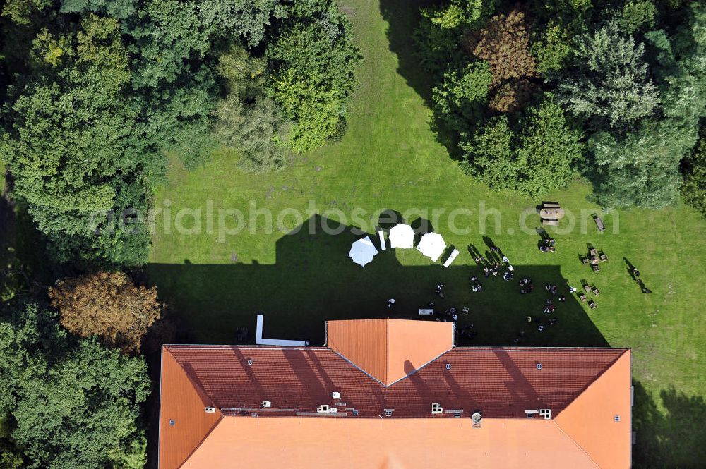 Hoppenrade from the bird's eye view: Schloss Hoppenrade ist eine der bedeutenden barocken Anlagen in Brandenburg. Es wurde auf den Fundamenten einer Wasserburg errichtet, die vermutlich Hans von Bredow in der zweiten Hälfte des 15. Jahrhunderts bauen ließ. 1723 wurde der Vorgängerbau abgetragen und anschließend das Herrenhaus als eingeschossige Dreiflügelanlage erbaut. Im rechten Seitenflügel wurde die Dorfkirche untergebracht. Heute ist die Immobilie -nach neuestem Stand ausgebaut- als Veranstaltungs- und Hochtzeitsschloß zu mieten. Hoppenrade Castle is one of the major baroque installations in Brandenburg.