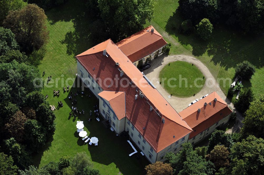 Aerial image Hoppenrade - Schloss Hoppenrade ist eine der bedeutenden barocken Anlagen in Brandenburg. Es wurde auf den Fundamenten einer Wasserburg errichtet, die vermutlich Hans von Bredow in der zweiten Hälfte des 15. Jahrhunderts bauen ließ. 1723 wurde der Vorgängerbau abgetragen und anschließend das Herrenhaus als eingeschossige Dreiflügelanlage erbaut. Im rechten Seitenflügel wurde die Dorfkirche untergebracht. Heute ist die Immobilie -nach neuestem Stand ausgebaut- als Veranstaltungs- und Hochtzeitsschloß zu mieten. Hoppenrade Castle is one of the major baroque installations in Brandenburg.