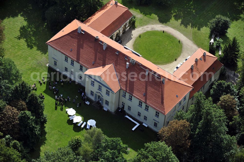 Aerial photograph Hoppenrade - Schloss Hoppenrade ist eine der bedeutenden barocken Anlagen in Brandenburg. Es wurde auf den Fundamenten einer Wasserburg errichtet, die vermutlich Hans von Bredow in der zweiten Hälfte des 15. Jahrhunderts bauen ließ. 1723 wurde der Vorgängerbau abgetragen und anschließend das Herrenhaus als eingeschossige Dreiflügelanlage erbaut. Im rechten Seitenflügel wurde die Dorfkirche untergebracht. Heute ist die Immobilie -nach neuestem Stand ausgebaut- als Veranstaltungs- und Hochtzeitsschloß zu mieten. Hoppenrade Castle is one of the major baroque installations in Brandenburg.