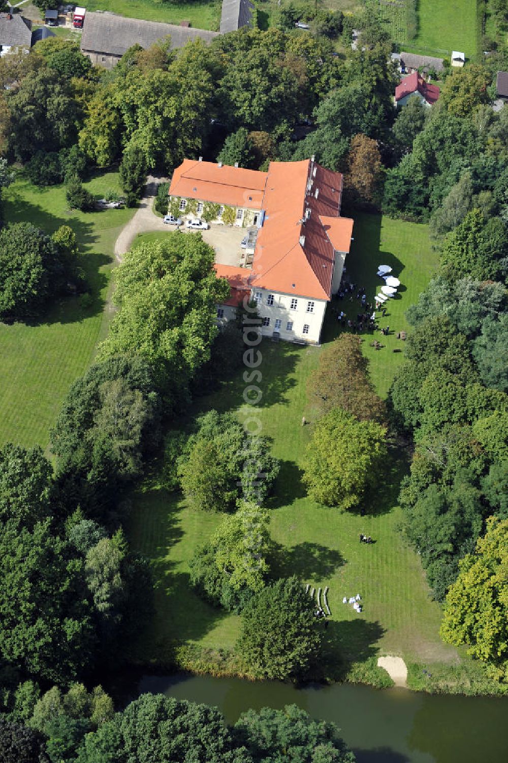 Aerial photograph Hoppenrade / Löwenberger Land - Schloss Hoppenrade ist eine der bedeutenden barocken Anlagen in Brandenburg. Es wurde auf den Fundamenten einer Wasserburg errichtet, die vermutlich Hans von Bredow in der zweiten Hälfte des 15. Jahrhunderts bauen ließ. 1723 wurde der Vorgängerbau abgetragen und anschließend das Herrenhaus als eingeschossige Dreiflügelanlage erbaut. Im rechten Seitenflügel wurde die Dorfkirche untergebracht. Heute ist die Immobilie -nach neuestem Stand ausgebaut- als Veranstaltungs- und Hochtzeitsschloß zu mieten. Hoppenrade Castle is one of the major baroque installations in Brandenburg.