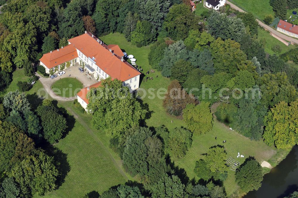 Hoppenrade / Löwenberger Land from the bird's eye view: Schloss Hoppenrade ist eine der bedeutenden barocken Anlagen in Brandenburg. Es wurde auf den Fundamenten einer Wasserburg errichtet, die vermutlich Hans von Bredow in der zweiten Hälfte des 15. Jahrhunderts bauen ließ. 1723 wurde der Vorgängerbau abgetragen und anschließend das Herrenhaus als eingeschossige Dreiflügelanlage erbaut. Im rechten Seitenflügel wurde die Dorfkirche untergebracht. Heute ist die Immobilie -nach neuestem Stand ausgebaut- als Veranstaltungs- und Hochtzeitsschloß zu mieten. Hoppenrade Castle is one of the major baroque installations in Brandenburg.