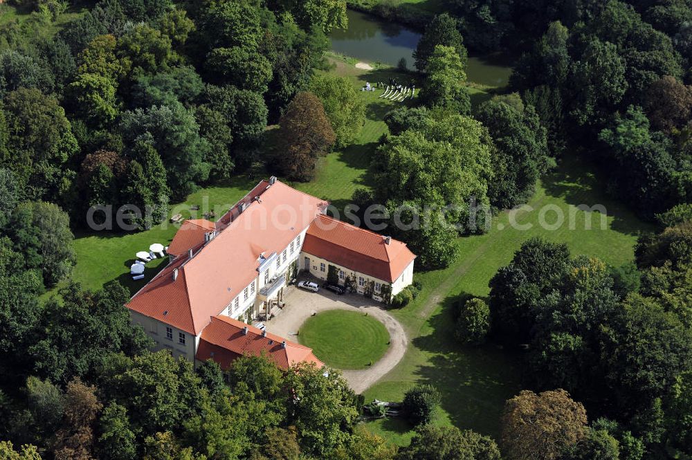 Aerial photograph Hoppenrade / Löwenberger Land - Schloss Hoppenrade ist eine der bedeutenden barocken Anlagen in Brandenburg. Es wurde auf den Fundamenten einer Wasserburg errichtet, die vermutlich Hans von Bredow in der zweiten Hälfte des 15. Jahrhunderts bauen ließ. 1723 wurde der Vorgängerbau abgetragen und anschließend das Herrenhaus als eingeschossige Dreiflügelanlage erbaut. Im rechten Seitenflügel wurde die Dorfkirche untergebracht. Heute ist die Immobilie -nach neuestem Stand ausgebaut- als Veranstaltungs- und Hochtzeitsschloß zu mieten. Hoppenrade Castle is one of the major baroque installations in Brandenburg.