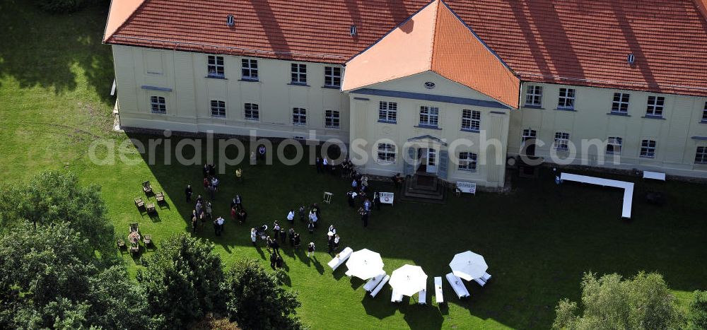 Aerial image Hoppenrade / Löwenberger Land - Schloss Hoppenrade ist eine der bedeutenden barocken Anlagen in Brandenburg. Es wurde auf den Fundamenten einer Wasserburg errichtet, die vermutlich Hans von Bredow in der zweiten Hälfte des 15. Jahrhunderts bauen ließ. 1723 wurde der Vorgängerbau abgetragen und anschließend das Herrenhaus als eingeschossige Dreiflügelanlage erbaut. Im rechten Seitenflügel wurde die Dorfkirche untergebracht. Heute ist die Immobilie -nach neuestem Stand ausgebaut- als Veranstaltungs- und Hochtzeitsschloß zu mieten. Hoppenrade Castle is one of the major baroque installations in Brandenburg.