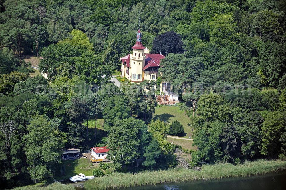 Storkow from the bird's eye view: Blick auf das 5-Sterne-Hotel bei Hubertushöhe am Storkower See. Das Jagdschloss wurde im Landhausstil erbaut und zeigt verschiedene Drachenelemente. Das Hotel bietet 23 luxuriöse Zimmer und Suiten an. View of the five-star hotel Hubertushoehe on Lake Storkow. The hunting lodge was built in the country house style and shows several dragon elements. The hotel offers 23 luxurious rooms and suites.