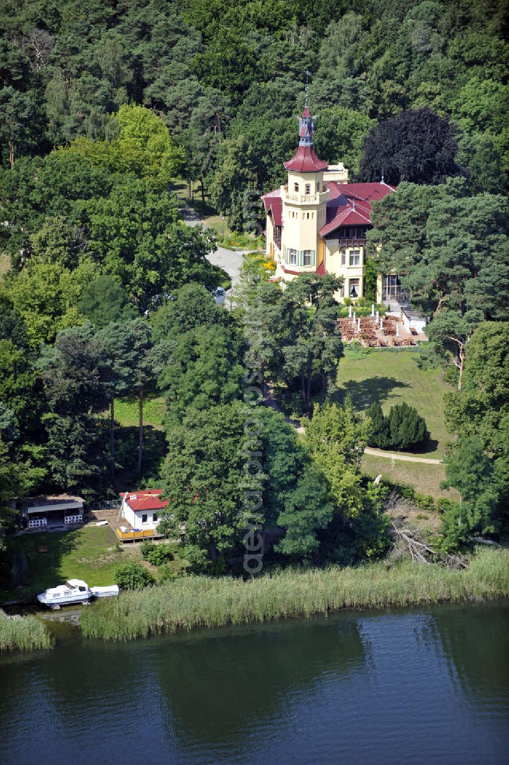 Aerial image Storkow - Blick auf das 5-Sterne-Hotel bei Hubertushöhe am Storkower See. Das Jagdschloss wurde im Landhausstil erbaut und zeigt verschiedene Drachenelemente. Das Hotel bietet 23 luxuriöse Zimmer und Suiten an. View of the five-star hotel Hubertushoehe on Lake Storkow. The hunting lodge was built in the country house style and shows several dragon elements. The hotel offers 23 luxurious rooms and suites.