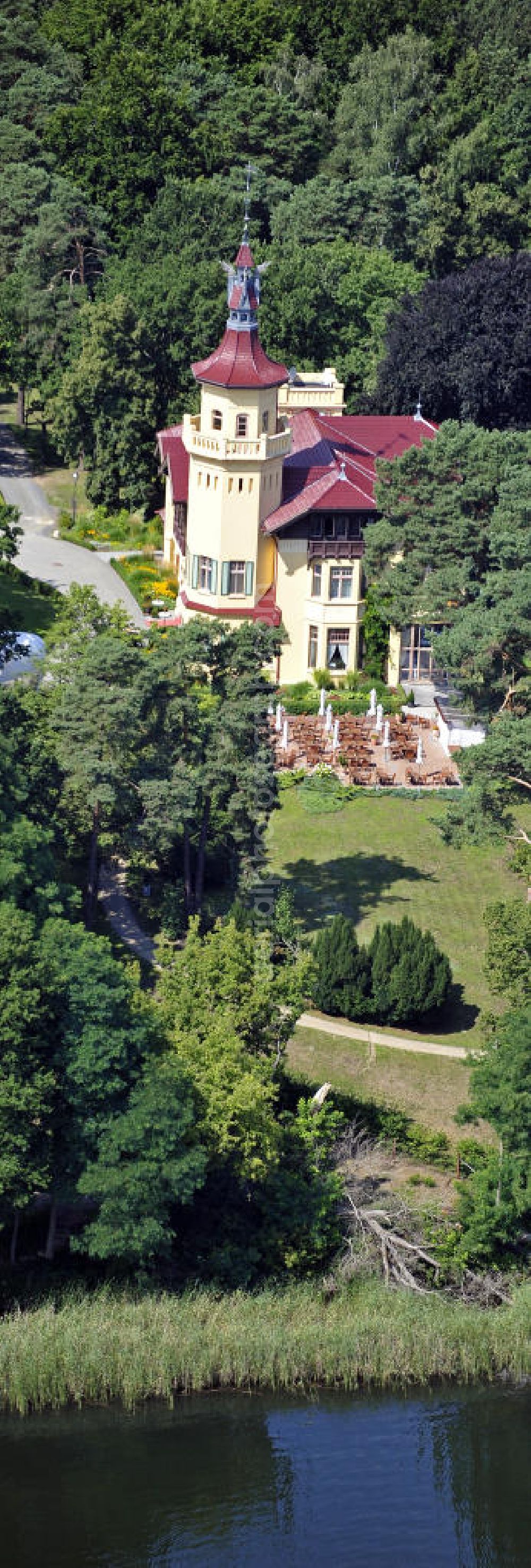 Storkow from above - Blick auf das 5-Sterne-Hotel bei Hubertushöhe am Storkower See. Das Jagdschloss wurde im Landhausstil erbaut und zeigt verschiedene Drachenelemente. Das Hotel bietet 23 luxuriöse Zimmer und Suiten an. View of the five-star hotel Hubertushoehe on Lake Storkow. The hunting lodge was built in the country house style and shows several dragon elements. The hotel offers 23 luxurious rooms and suites.