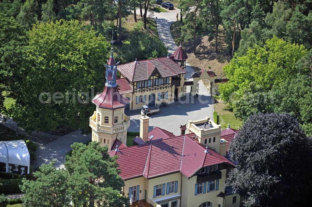 Storkow from above - Blick auf das 5-Sterne-Hotel bei Hubertushöhe am Storkower See. Das Jagdschloss wurde im Landhausstil erbaut und zeigt verschiedene Drachenelemente. Das Hotel bietet 23 luxuriöse Zimmer und Suiten an. View of the five-star hotel Hubertushoehe on Lake Storkow. The hunting lodge was built in the country house style and shows several dragon elements. The hotel offers 23 luxurious rooms and suites.