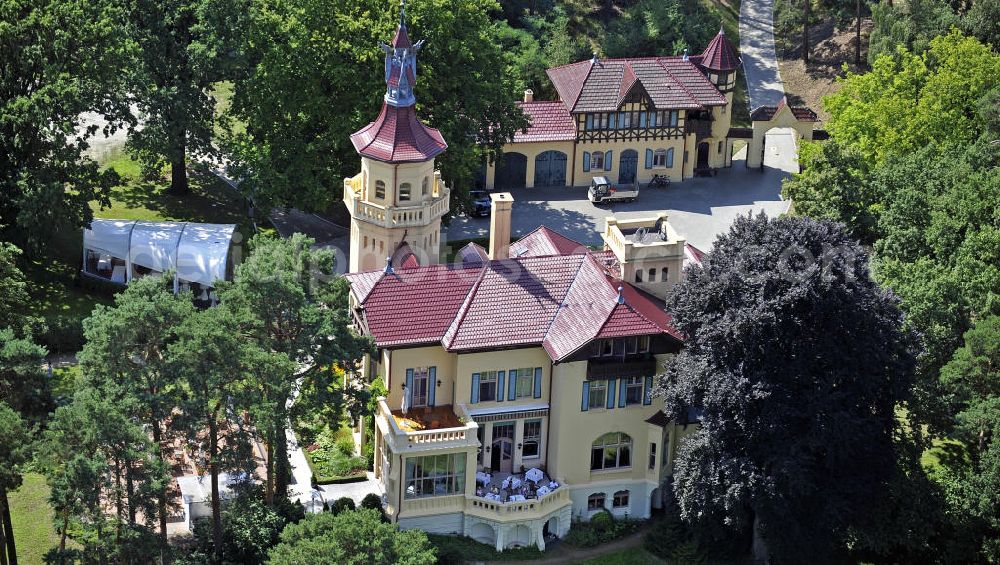 Aerial photograph Storkow - Blick auf das 5-Sterne-Hotel bei Hubertushöhe am Storkower See. Das Jagdschloss wurde im Landhausstil erbaut und zeigt verschiedene Drachenelemente. Das Hotel bietet 23 luxuriöse Zimmer und Suiten an. View of the five-star hotel Hubertushoehe on Lake Storkow. The hunting lodge was built in the country house style and shows several dragon elements. The hotel offers 23 luxurious rooms and suites.