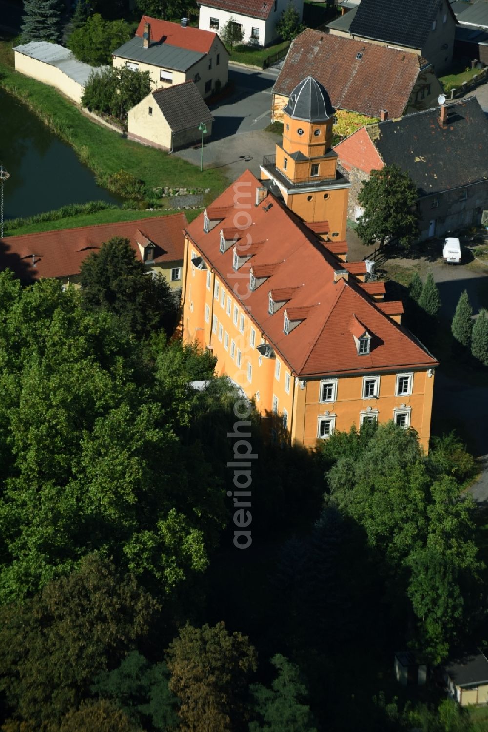 Kühnitzsch from the bird's eye view: Castle of Schloss Kuehnitzsch in Kuehnitzsch in the state of Saxony. The former water castle is located on a small pond with its yellow front and tower